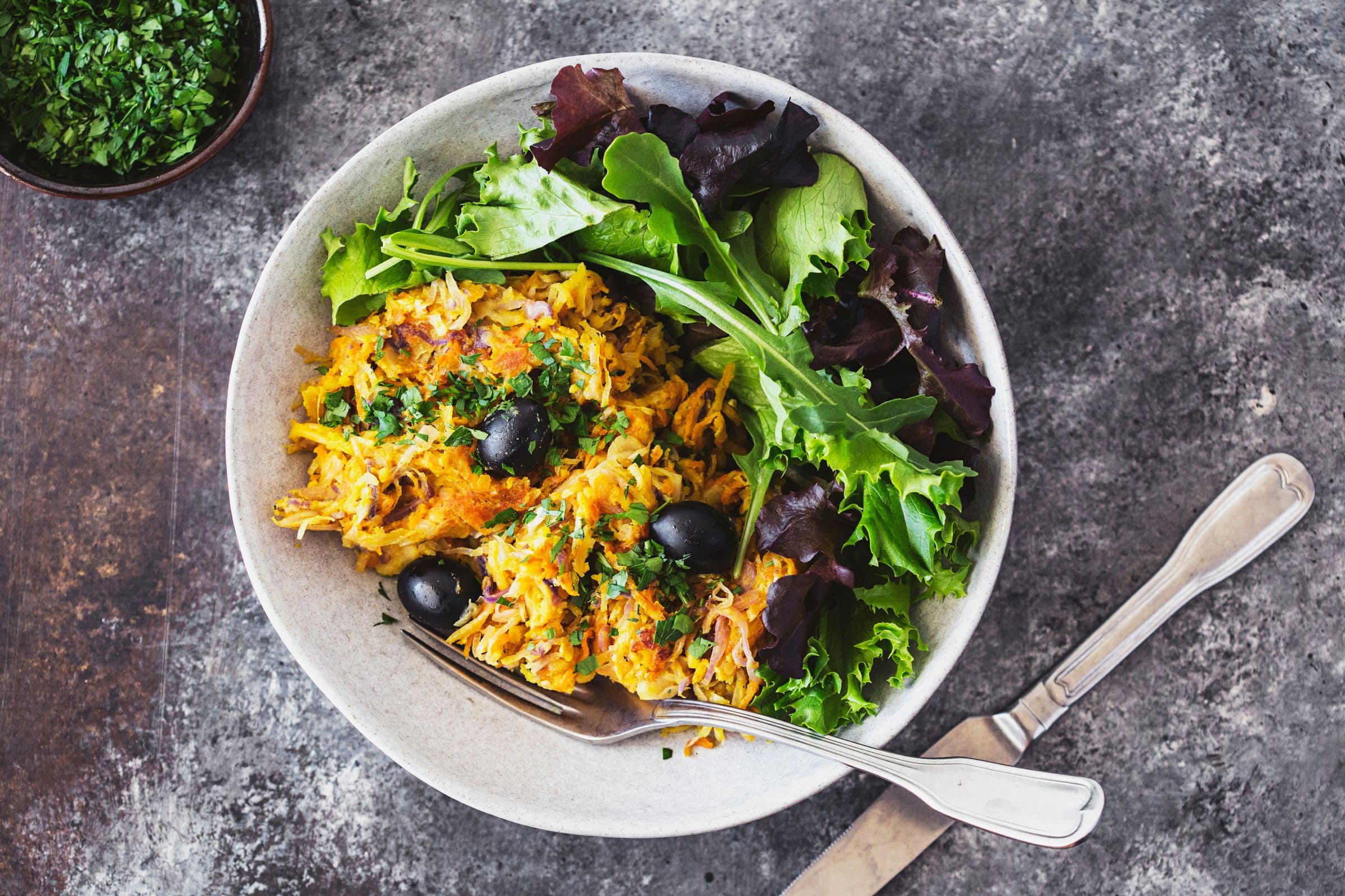 Portuguese veggie hash plated with fresh green salad on the side.