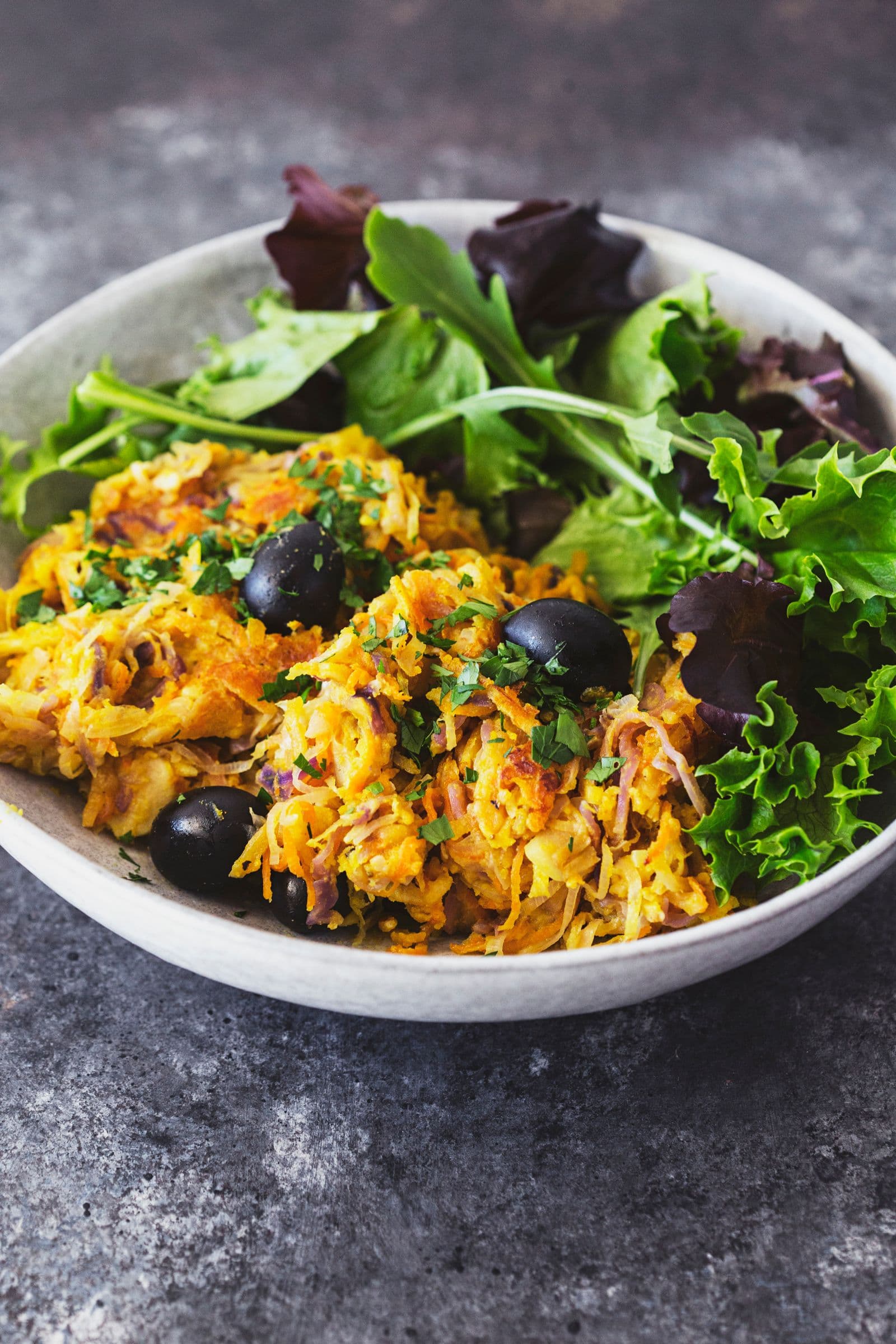 Portuguese veggie hash plated with fresh green salad on the side.