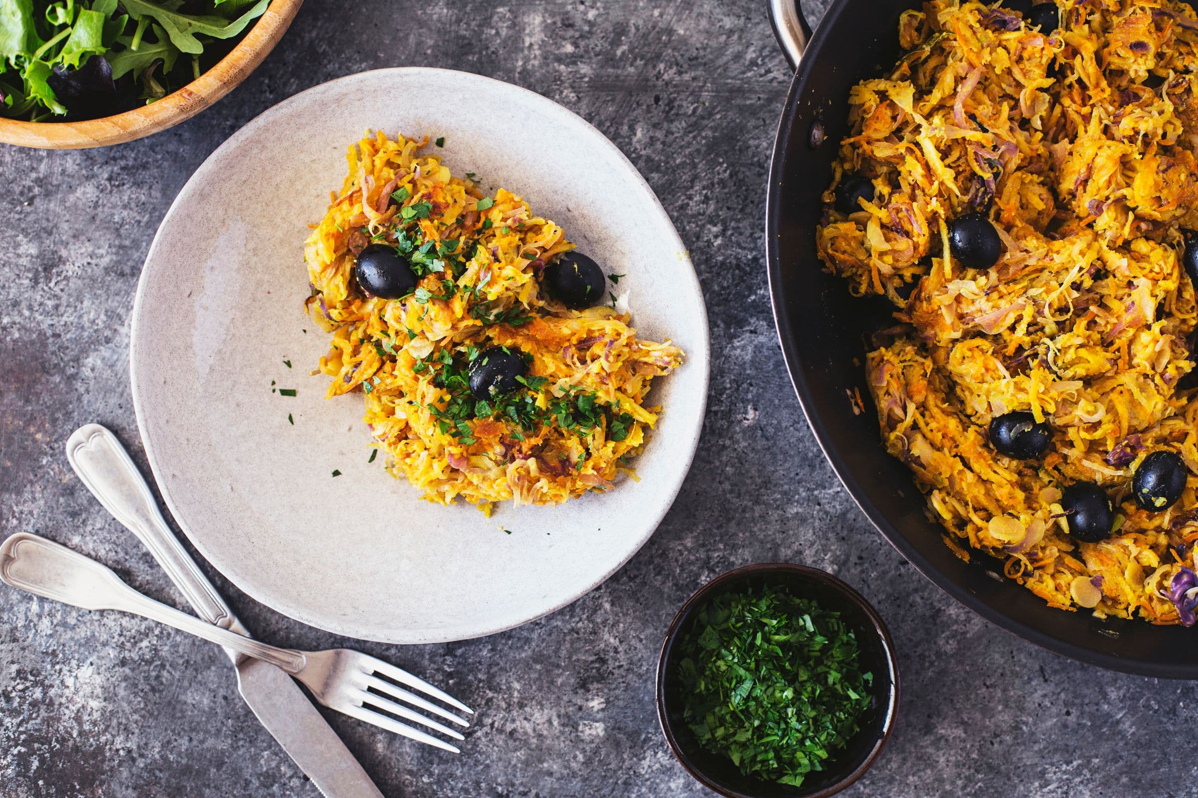 Portuguese veggie hash plated with fresh green salad on the side.